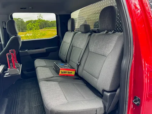 Rear bench-seat close-up showing three-seat layout and seatbelt positions.